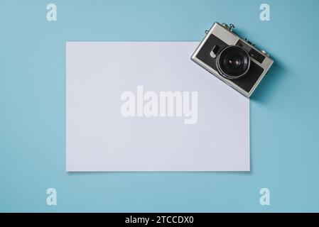 Vintage photo camera and empty photo frames on blue background. Travel moment concept Stock Photo