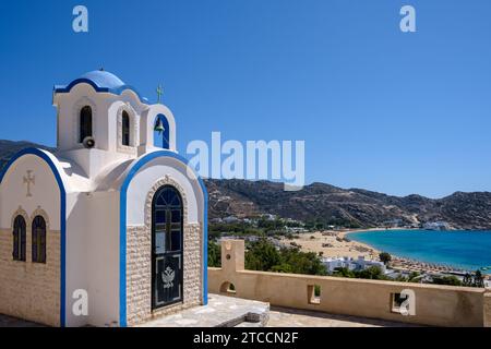 View of the little picturesque chapel Saint George overlooking the beautiful Mylopotas Beach in Ios Greece Stock Photo