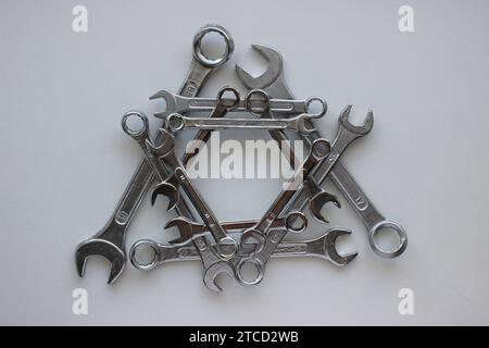 Geometrically laid out in a triangular shape, chrome plated wrenches of different sizes Stock Photo