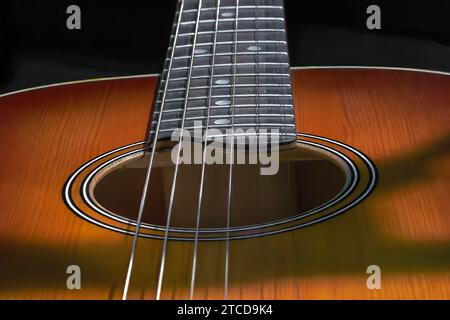 Image of a resonant hole in the soundboard of a guitar neck with strings Stock Photo