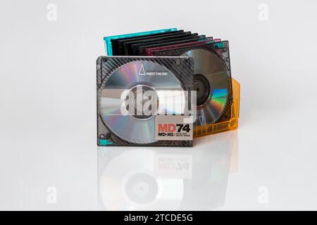 Front view of a minidisc standing upright in front of a folding stand with other mini discs on a white background with reflection Stock Photo