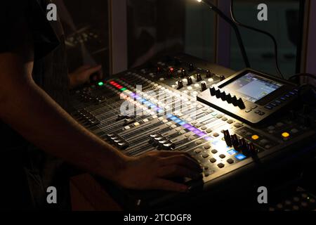 unrecognizable sound technician operating a multitrack mixing console in the control room during an event Stock Photo
