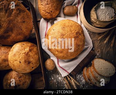 Assortment of baked bread on rustic wooden background, flat lay Stock Photo