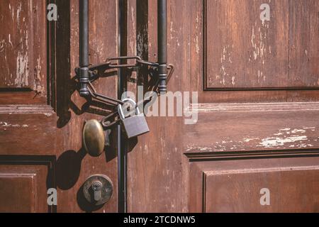 old wooden door locked with rusty chain death lock. closed abandoned house nobody living, people leave and sale home. Stock Photo