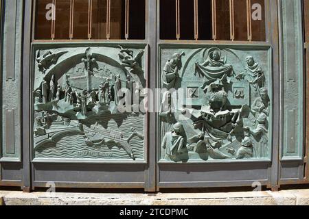 Oxidized green copper relief depicting biblical scenes of the Apocalypse chapter on the gate of the San Lorenzo cathedral in the centre of Trapani Stock Photo