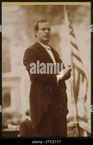 William Jennings Bryan, Democratic party presidential candidate, three-quarter length view standing on stage next to American flag Stock Photo