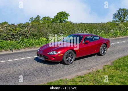 1998 90s nineties Red British Jaguar XK8 3999 cc 5 speed automatic  2dr coupe; Vintage, restored classic motors, automobile collectors motoring enthusiasts, historic veteran cars travelling in Cheshire, UK Stock Photo