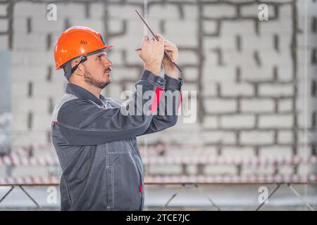 A construction worker uses modern digital technologies in the process of his professional construction work Stock Photo