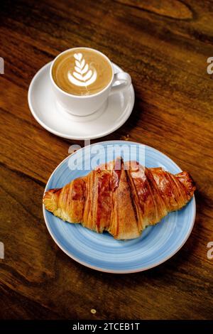 Freshly Baked Croissant with coffee on Wooden Table Stock Photo