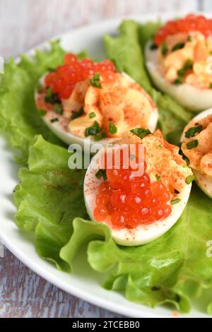 Stuffed eggs with salmon caviar are a popular appetizer for any occasion. Elegantly decorated and expertly seasoned, they will always be a beautiful a Stock Photo