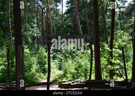 Wooden sign saying 'Beestige Boelbos' in the shade of the tree in a forest in the Mechelse Heide national park Stock Photo