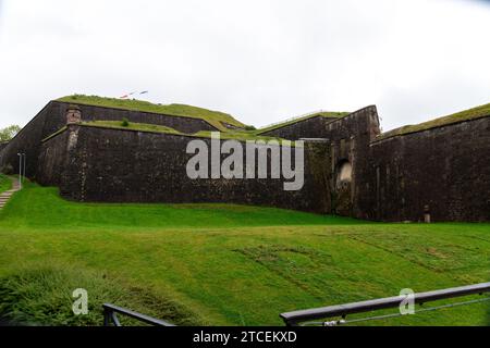 The walls of the citadel of Belfort with a lush green lawn in front of it, in which a script has been mown in Stock Photo