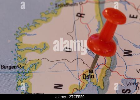 A red pin stuck into a map of Western Europe, pinpointing the location of Oslo Stock Photo