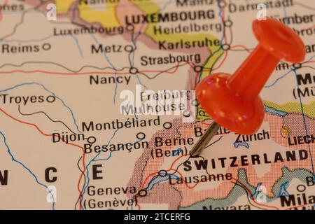 A red pin stuck into a map of Western Europe, pinpointing the location of Bern Stock Photo