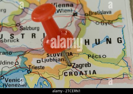 A red pin stuck into a map of Western Europe, pinpointing the location of Zagreb Stock Photo