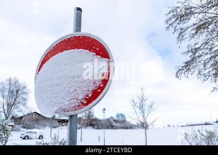 Bavaria, Germany - November 26, 2023: Snow-covered unrecognizable traffic sign. Road sign full of snow *** Zugeschneites unkenntliches Verkehrsschild. Straßenschild voller Schnee Stock Photo