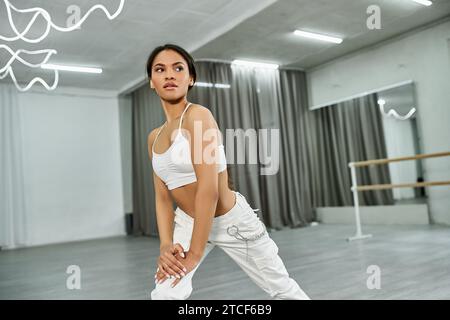 professional african american dancer in white sportswear rehearsing and practicing in dance hall Stock Photo