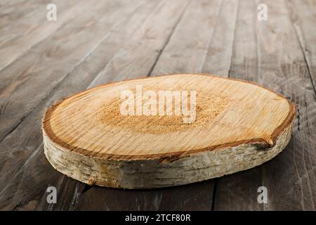 Wooden rustic cutting board isolated on wooden table. Stock Photo