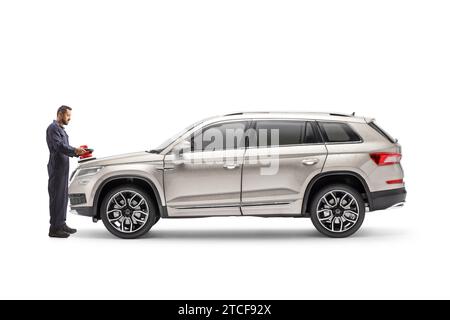 Full length profile shot of a worker polishing a car with a buffer isolated on white background Stock Photo