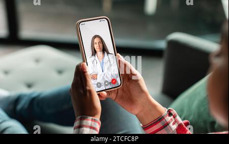 Telemedicine. Unrecognizable Woman Using Smartphone, Making Video Conference With Her Therapist Doctor Stock Photo