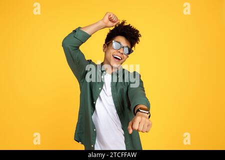 Carefree young black guy wearing sunglasses dancing Stock Photo