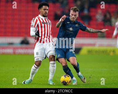 Swansea City's Josh Tymon (left) and Stoke City's Junior Tchamadeu ...