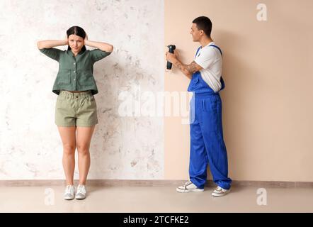 Young woman suffering from loud neighbour renovating at home Stock Photo