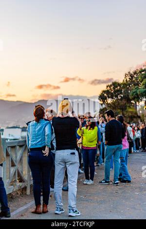 Tourists taking photos in Santa Monica, California, at sunset with the Santa Monica Mountains in the background Stock Photo