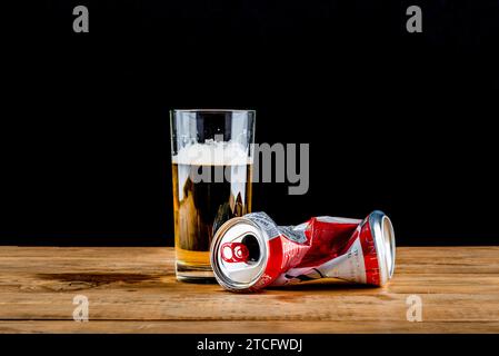Moscow, Russia - December 08, 2023: A glass of beer and a crumpled can of Bud beer on a wooden rough table. Copy space. Stock Photo