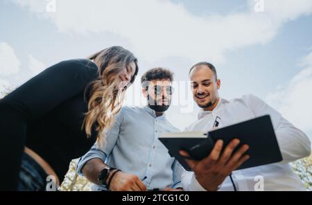 Students collaborate outdoors to achieve academic success through teamwork, discuss school subjects, and preparing for exams and university projects. Stock Photo