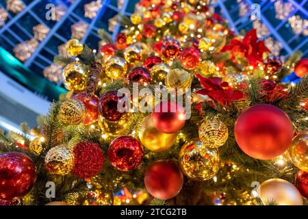 Christmas tree full of lights, garlands, colorful balls and decorations. Abstract Christmas background. Bottom-up view of Christmas tree. Stock Photo
