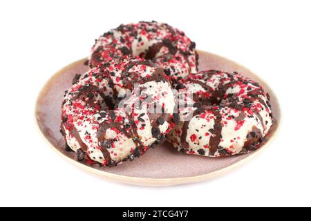Three colorful donuts on pink plate isolated on white background. Stock Photo