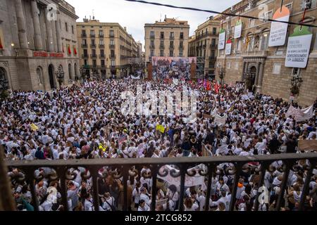 Barcelona, Spain. 12th Dec, 2023. Crowds of workers and nurses from the public health system flock the Plaza de Sant Jaume in front of the headquarters of the Presidency of Catalonia. Called by a group of minority unions, thousands of nurses and administrative staff of the public health service have demonstrated in the center of Barcelona to improve their working conditions and show their rejection of the agreement between the majority unions and the administration known as the “III acord”. Credit: SOPA Images Limited/Alamy Live News Stock Photo