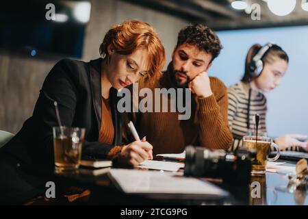 Business professionals collaborate in office, analyzing data, planning project development, and discussing marketing strategies for growth. Stock Photo