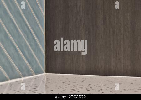 Empty corner alcove cube made with three different contrasting materials of tiled wall, wooden furniture and marble countertop. Stock Photo