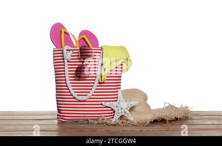 Stylish bag, starfish and other beach accessories on wooden table against white background Stock Photo
