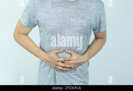 Man suffering with severe stomach pain. Hand of mature guy holding abdomen suffering from ache, diarrhea or indigestion problem. Stock Photo
