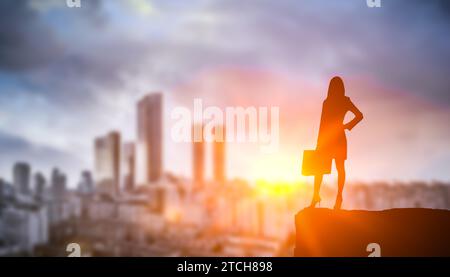 silhouette business woman on sunset city background. confident, strong, smart businesswoman looks on skyscrapers. women building career in business, p Stock Photo