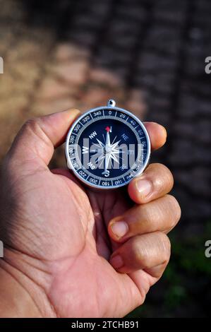 Hand holding a compass with blur background Stock Photo