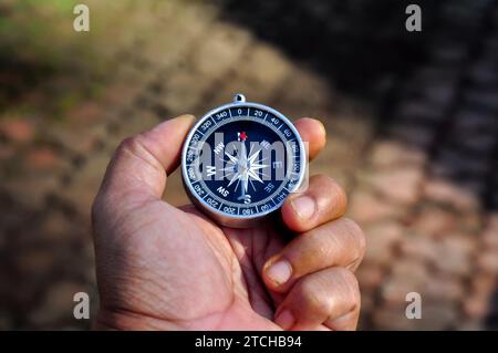Hand holding a compass with blur background Stock Photo