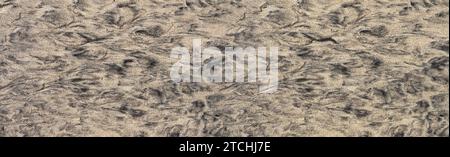 Abstract pattern of black and brown sand in a flat ground on the beach Stock Photo