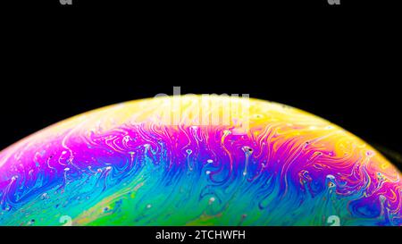 Abstract background made from soap bubble reflecting light. Rainbow soap bubble on a dark background Stock Photo