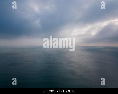 Aerial view of a dark sea, horizon, and dramatic sky before a storm. Stock Photo