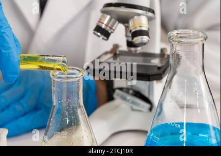Close-up of scientist wearing blue gloves and using laboratory tools Stock Photo