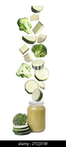 Baby food. Fresh broccoli and slices of zucchini falling into jar of puree on white background Stock Photo