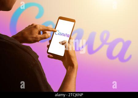 pringsewu, Lampung; December 14, 2023; A man's hand holds an Android phone with the Canva logo, isolated background computer blurred Canva logo. edito Stock Photo