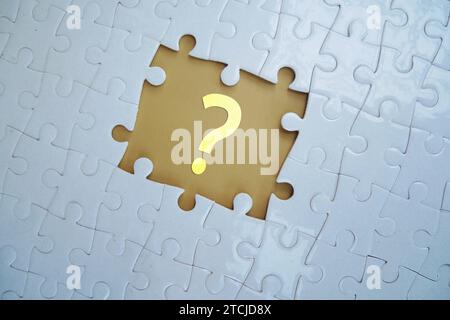 Question mark on jigsaw puzzle with missing piece. Concept of question, FAQ, Q and A, confusion and solution. Stock Photo