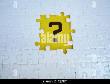 Question mark on jigsaw puzzle with missing piece. Concept of question, FAQ, Q and A, confusion and solution. Stock Photo