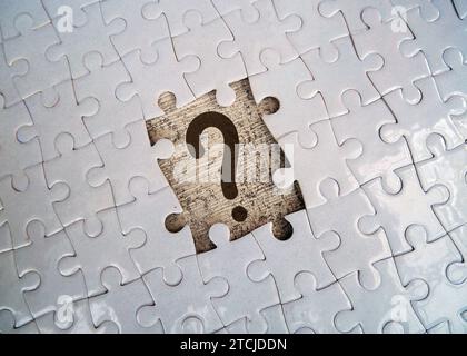 Question mark on jigsaw puzzle with missing piece. Concept of question, FAQ, Q and A, confusion and solution. Stock Photo