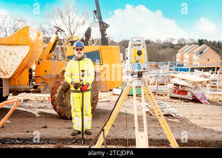 Surveyor builder site engineer with theodolite total station at construction site outdoors during surveying work Stock Photo